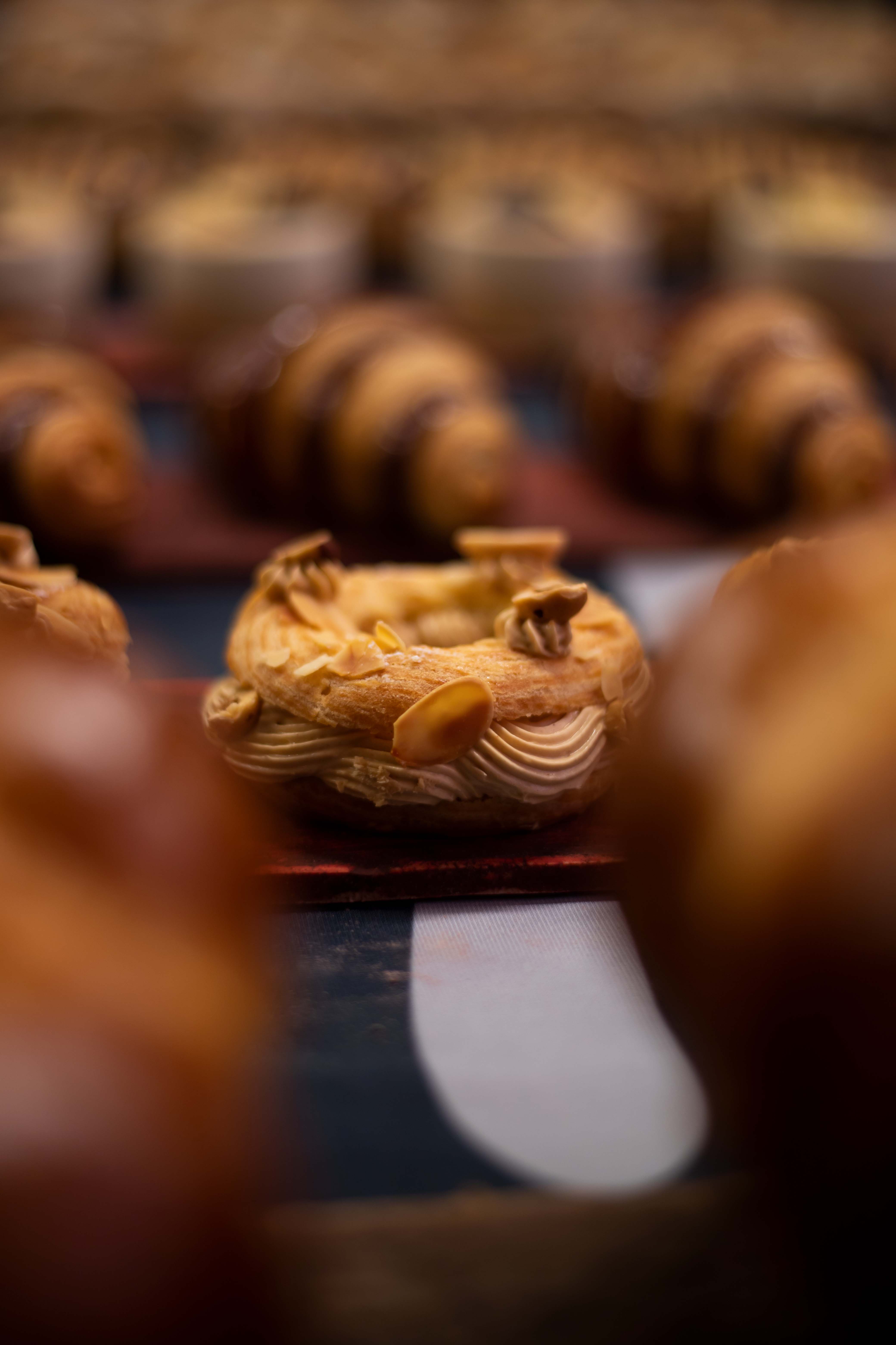 Photo au format portrait de mini Paris-Brest derrière deux brioches  de l'INBP de Rouen
